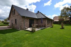 a brick house with a green lawn in front of it at Dat Dardel Hus in Born