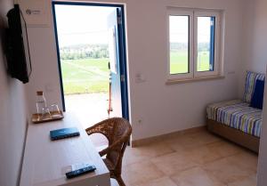 a room with a table and a couch and a window at Casas Do Rio Sado - Sado River Country Retreat in Santa Margarida do Sado