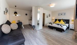 a bedroom with a bed and a couch at Apart Hotel Dillinger Schwabennest in Dillingen an der Donau