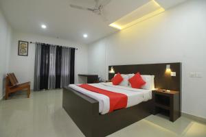 a bedroom with a large bed with red pillows at Half Moon Residency Calicut in Kozhikode