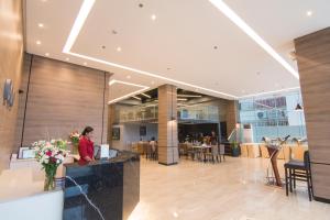 卡瓦延市Mango Suites Cauayan的一位女士坐在大厅的柜台前