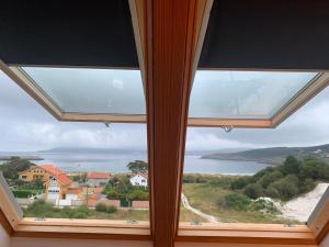 ラシェにあるAtico Nuevo (WIFI) en Laxeの海の景色を望む家の大きな窓