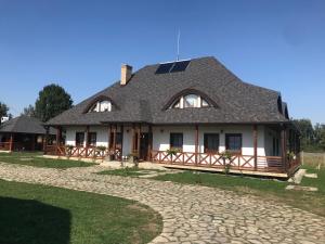 a large white house with a gambrel roof at Casa Strabunicului in Pîrteştii de Sus
