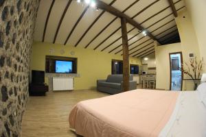 a bedroom with a bed and a living room at Etna Paradise locazioni brevi in Ragalna