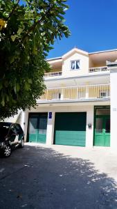 a building with two garage doors and a car parked in front at Apartments Niksa Kastelan in Omiš