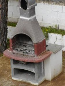 um forno de pizza ao ar livre ao lado de uma parede de tijolos em El Pinar De Villa Carmina em Cerro Muriano