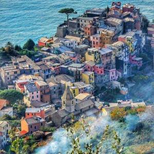 a group of buildings on a hill next to the ocean at La Ginestra in Corniglia