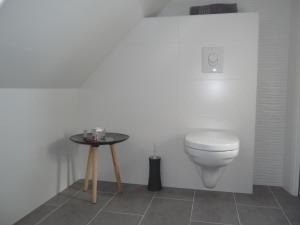 ein Bad mit einem WC und einem Tisch in der Unterkunft Charmant sudio aux portes de Colmar in Durrenentzen
