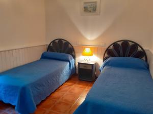 - une chambre avec deux lits et une lampe sur une table dans l'établissement Appartement Côté Sud vert, à Sarlat-la-Canéda