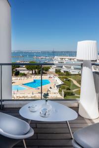 
a dining room table with a balcony overlooking the ocean at Hotel & Spa Les Bains de Camargue by Thalazur in Le Grau-du-Roi
