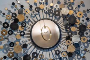 a round mirror on a wall with a bunch of objects at Thalazur Port-Camargue - Hotel & Spa in Le Grau-du-Roi