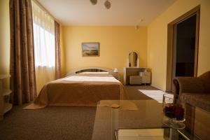 a hotel room with a bed and a couch at Egliu Slenis in Juodkrantė