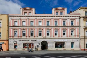 um grande edifício cor-de-rosa numa rua da cidade em Avantgarde apartments em Plzeň