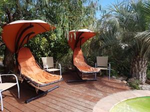 a deck with chairs and umbrellas next to a pool at LES PALMIERS TOULON in Toulon