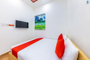 1 dormitorio con 1 cama con almohadas rojas y TV en M&C Hotel Nha Trang en Nha Trang