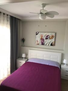 アデへにあるPlaya de Fañabé MareVerdeのベッドルーム(紫色のベッド1台、天井ファン付)