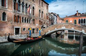 een gondel in een kanaal met een brug bij Palazzo Marcello Hotel Al Sole in Venetië