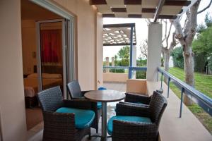 a patio with a table and chairs and a bedroom at Aithrio Hotel in Niforeika