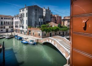 boats are docked in the water near a large building at Palazzo Marcello Hotel Al Sole in Venice
