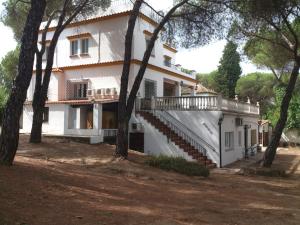 een groot wit huis met trappen en bomen bij El Pinar De Villa Carmina in Cerro Muriano