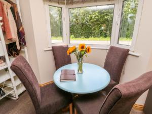 una mesa con sillas y un jarrón de flores. en Mallard Cottage, en Tadcaster