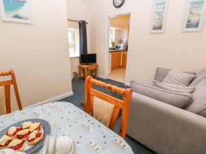 a living room with a table and a couch at The Old Cows House in Helston