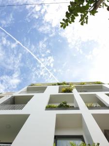 a white building with windows and a blue sky at Lem's Apartment & Coffee in Da Nang