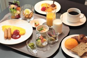 a table with plates of breakfast foods and glasses of milk at Piazza Hotel Nara in Nara