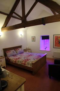 The White Hart في Sherington: غرفة نوم مع سرير ونافذة مع ضوء أرجواني