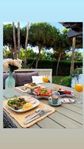 uma mesa com pratos de comida e copos de sumo de laranja em Luxury apartment in La Isla, Puerto Banus em Marbella
