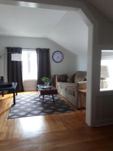 a living room with a couch and a clock on the wall at Willow B Inn in Kingsville