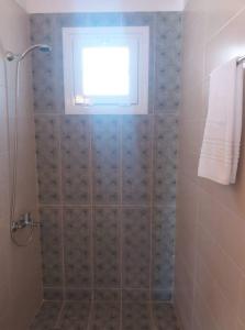 a bathroom with a shower with a window at Kedraki in Kalamaki
