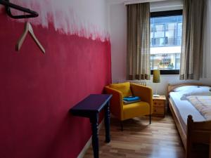 a hotel room with a bed and a yellow chair at Ruhrtropolis Hostel in Essen