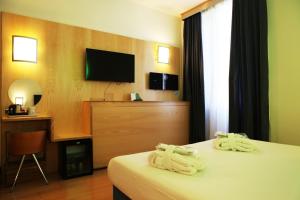 a hotel room with two beds and a television at Hotel Franklin Feel The Sound in Rome