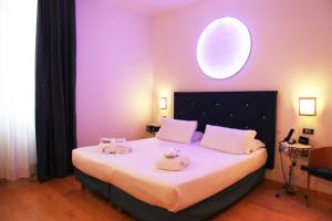a bedroom with a large bed with towels on it at Hotel Franklin Feel The Sound in Rome