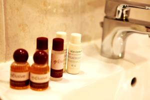 three bottles of hair products sitting on a bathroom sink at Hotel Franklin Feel The Sound in Rome