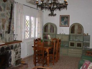 een eetkamer met een tafel en stoelen en een open haard bij El Pinar De Villa Carmina in Cerro Muriano