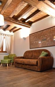 ein Wohnzimmer mit einem braunen Sofa und Stühlen in der Unterkunft Il Viaggiatore Appartamento in Anagni