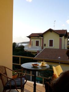 a person reading a book on a balcony with a table at Hotel Signorini in Castiglioncello