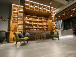 a lobby with two chairs and shelves with books at Tian Zhong Hotel in Tianzhong