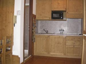 a kitchen with wooden cabinets and a sink at Cornostella in Foppolo