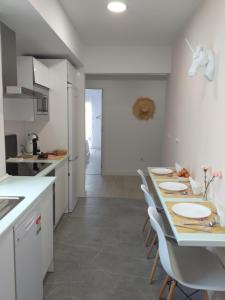 uma cozinha com armários brancos e uma mesa e cadeiras em PINK LEMON apartments em Córdoba