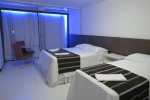 En eller flere senge i et værelse på Tirol Praia Hotel