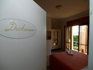 a bedroom with a bed and a sign on a wall at Hotel Signorini in Castiglioncello