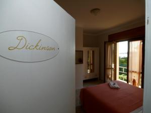 ein Schlafzimmer mit einem Bett und einem Schild an der Wand in der Unterkunft Hotel Pensione Signorini in Castiglioncello