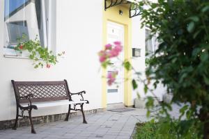 eine Bank, die vor einem Haus mit einer Tür sitzt in der Unterkunft Apartmani kod Marka in Požega