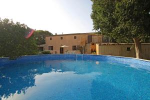 una grande piscina blu di fronte a una casa di Finca Son Xuric a Felanitx