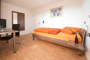 a bedroom with a bed and a desk at Hotel Merlin in Filderstadt