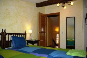 a bedroom with a blue and green bed and a mirror at Las Casas De "El Cerrillo" in Montesclaros