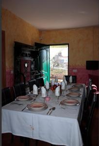 a long table with a white tablecloth and plates and chairs at Las Casas De "El Cerrillo" in Montesclaros